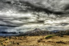 Storm clouds gather over Mojave desert sands.