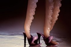 An octopus wearing purple plastic high heel mules.