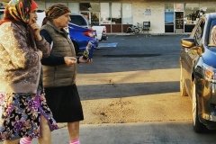 Two women in babushkas walk by a Los Angeles fast food mini mall.