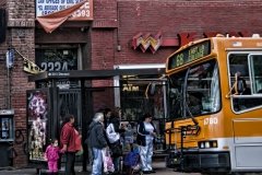 People get on an LA bus on Cesar Chavez Boulevard.